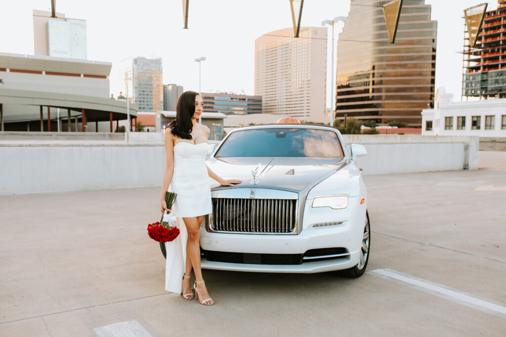 bride poses on a rooftop with a rolls royce after an elopement at the courthouse in arizona
