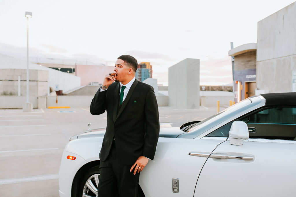 groom leans on rolls royce during bridal session in arizona