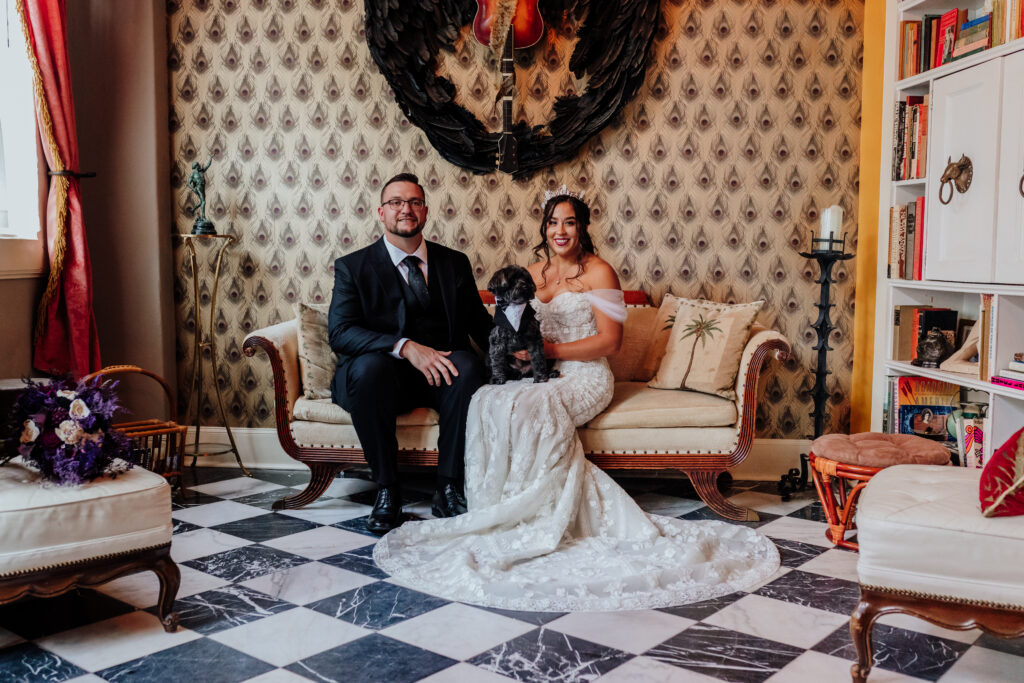 bride and groom pose with their dog at the courtyard wedding venue in bisbee arizona